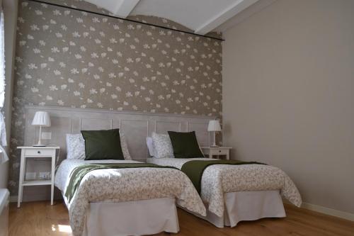 een slaapkamer met 2 bedden en een muur met bloemen bij La Locanda nel Frutteto in Rovereto