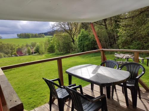 a table and chairs on a porch with a view of a field at Mobilní dům in Dolní Dvořiště