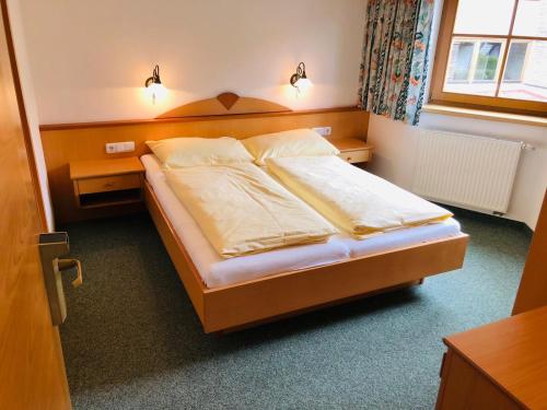 キルヒベルク・イン・チロルにあるFerienhaus Hotel Rösslwirtのベッド1台(2つの照明付)