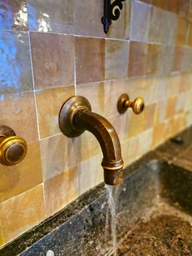 a sink with a water faucet on a wall at Old Bruges B&B in Bruges