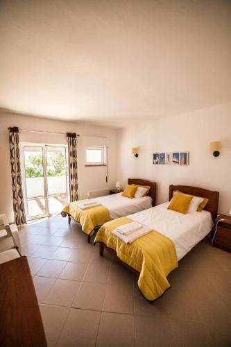 two beds in a large room with a window at Vivenda Jardim Mar Algarve Porches in Porches