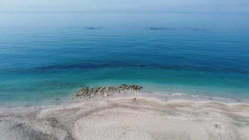 a group of rocks in the water on a beach at Hotel Centro Congressi Polo Nautico in Salerno