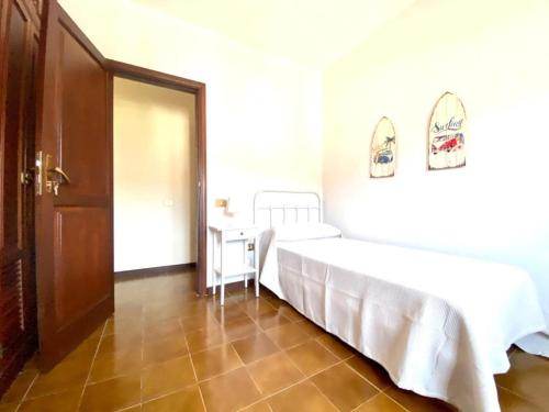 a bedroom with two beds and a table and a door at Vivienda Vacacional Villa El Mirador in San Sebastián de la Gomera