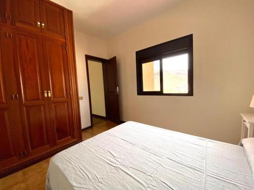 a bedroom with a white bed and a window at Vivienda Vacacional Villa El Mirador in San Sebastián de la Gomera