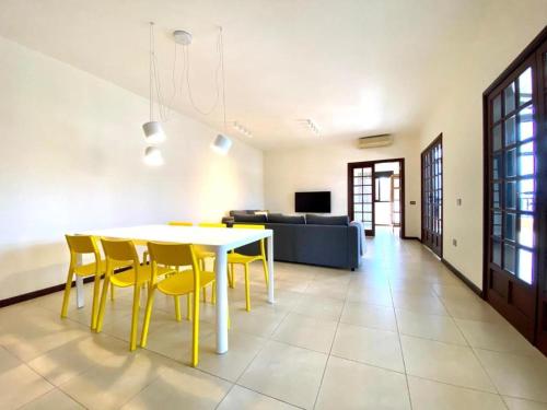 a dining room with a table and yellow chairs at Vivienda Vacacional Villa El Mirador in San Sebastián de la Gomera