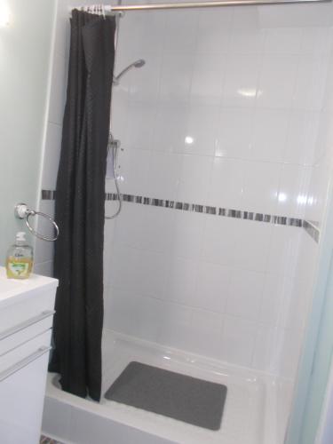 a bathroom with a shower with a black shower curtain at Webb's of Glomel in Glomel