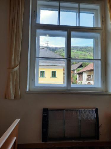 a window with a view of a yellow house at Gasthof Hochalmspitze in Malta