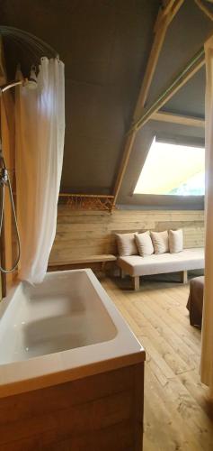 a bathroom with a large tub in a room at Agricamping La Gallinella in Castagneto Carducci