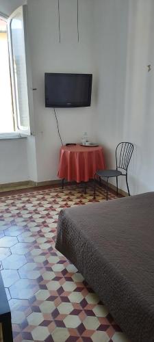 a room with a bed and a table and a tv at Arena Alfieri B&B in Livorno