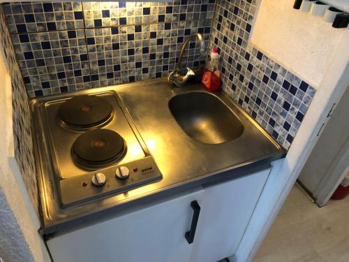 uma cozinha com um lavatório e um fogão em Le Vostok Zodiaque Soyouz em Le Corbier