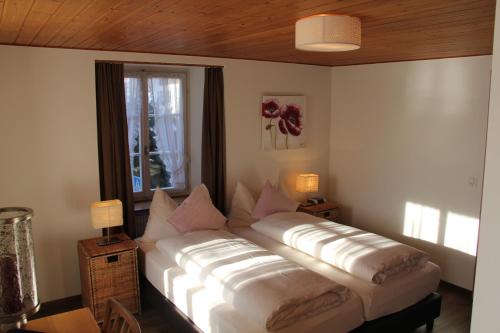 a large bed in a room with a window at Hotel Restaurant Rössli in Schönenberg