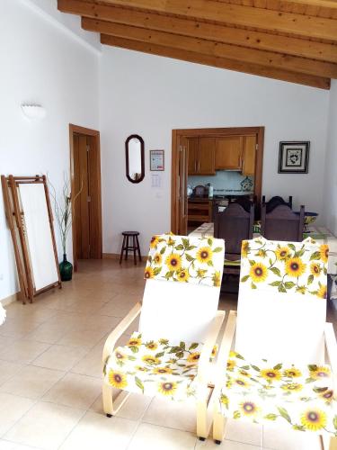 a living room with two chairs and a table at Casa Nova da Barreira in Cavaleiro