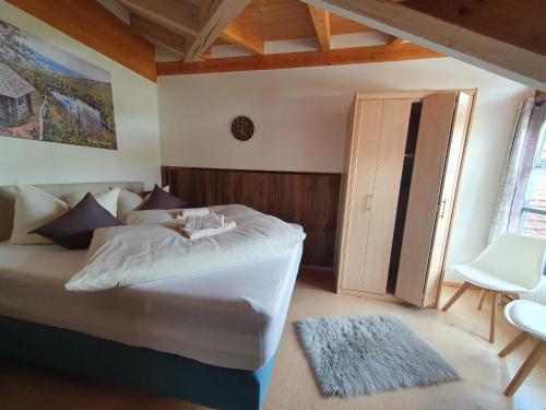 ein Schlafzimmer mit einem Bett, einem Stuhl und einem Fenster in der Unterkunft Ferienhaus Tonihof in Langdorf
