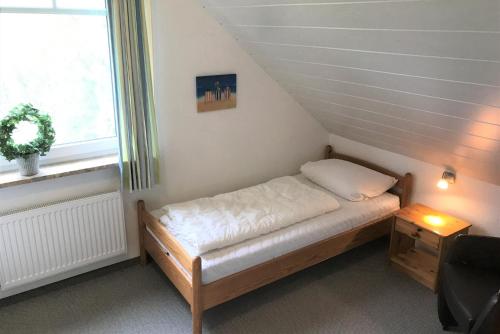 ein kleines Bett in einem Zimmer mit Fenster in der Unterkunft Ferienwohnung Karin in Cuxhaven