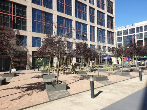 a courtyard with tables and chairs in front of a building at Bonito Apto Cinco Torres Plaza Castilla in Madrid