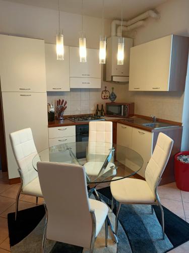 a kitchen with a glass table and white chairs at Luna in Cavalcaselle