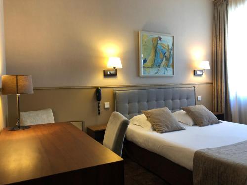 a hotel room with two beds and two lamps at Hotel Ajoncs d'Or in Saint Malo