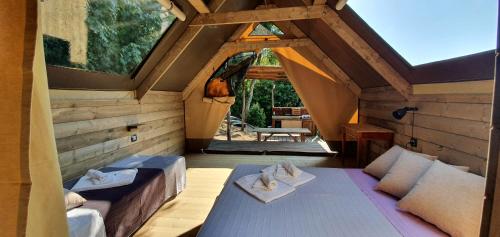 a room with two beds and a large window at Agricamping La Gallinella in Castagneto Carducci