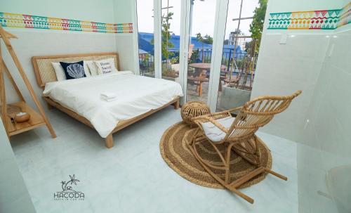 a bedroom with a bed and a rocking chair at Hacoda Homestay in Con Dao