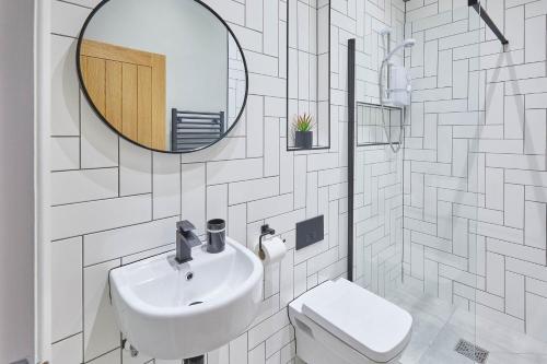 a bathroom with a sink and a mirror and a toilet at Host & Stay - North Marine House in Scarborough