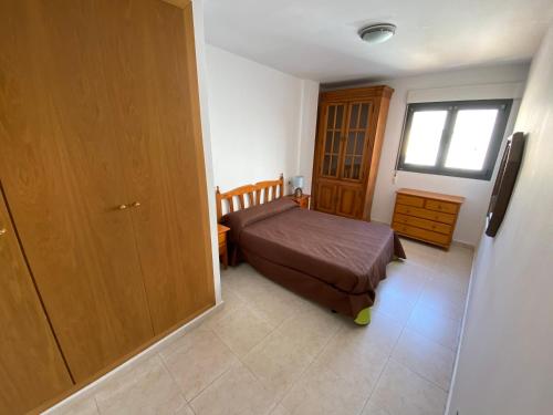 mała sypialnia z łóżkiem i oknem w obiekcie Apartamentos Sotavento Altamar w mieście Alcossebre