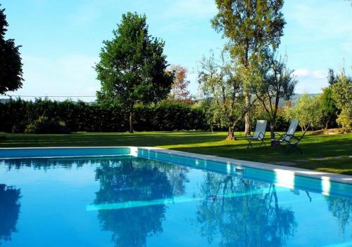 a swimming pool with two chairs in a yard at Santa Margherita Vacanze in Poggibonsi