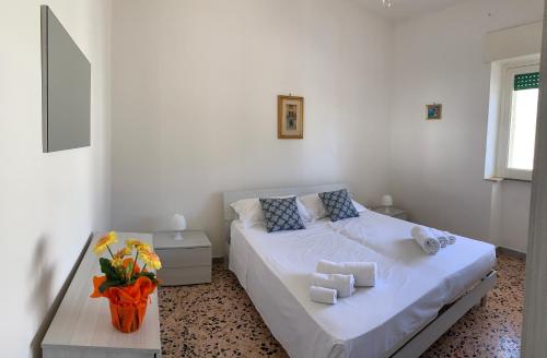 Dormitorio blanco con cama y mesa en Casa Dante, en Campomarino