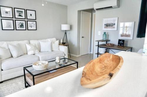 a living room with a white couch and a table at Serenity at Seascape: Steps to the beach & Shops in Palm Beach Shores
