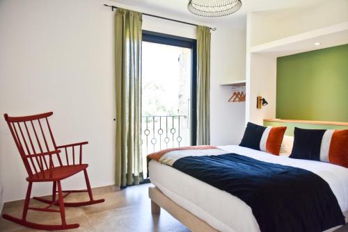 une chambre avec un lit, une chaise et une fenêtre dans l'établissement Casa di Neshama Gabriella, à Saint-Florent