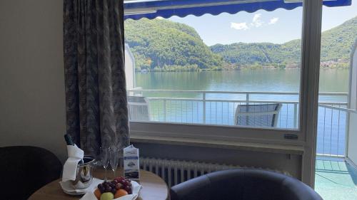a room with a window with a view of a lake at Tresa Bay Hotel in Ponte Tresa