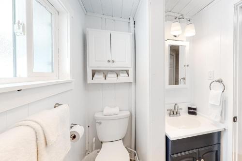 a white bathroom with a toilet and a sink at Sitting on the Dock of the Bay in Athol
