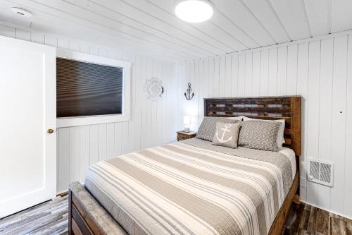 a bedroom with a large bed in a white room at Sitting on the Dock of the Bay in Athol