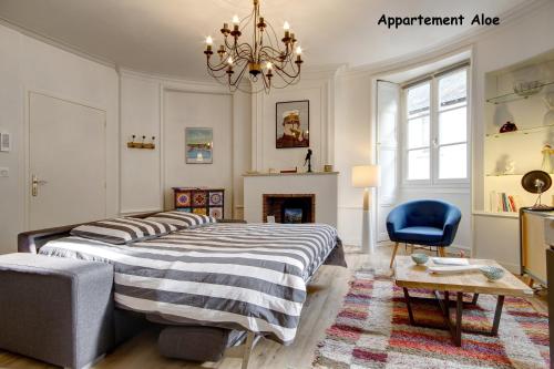 a bedroom with a bed and a chair and a chandelier at Appartements de caractère centre in Vannes