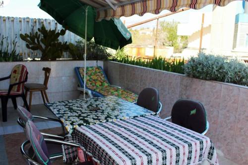 a table with chairs and an umbrella on a patio at Josip 2 Gajac in Novalja
