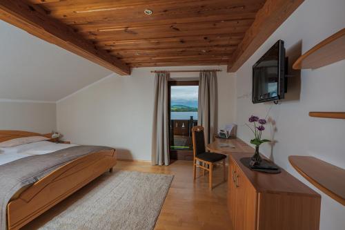 Schlafzimmer mit einem Bett und einem Schreibtisch mit einem TV in der Unterkunft Ferienwohnung Gaigg in Weyregg