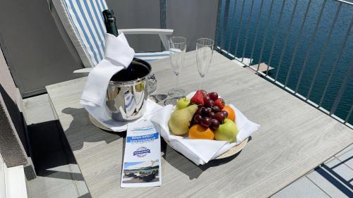 a table with a bottle of wine and a plate of fruit at Tresa Bay Hotel in Ponte Tresa