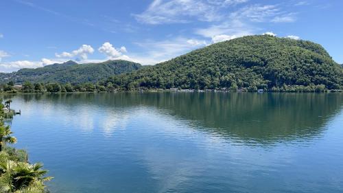 a large body of water with a mountain in the background at Tresa Bay Hotel in Ponte Tresa