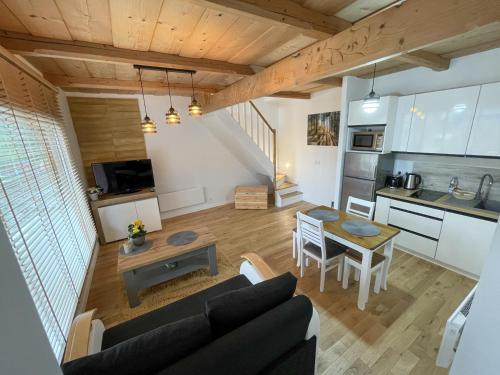 a living room and kitchen with a couch and a table at Apartamenty rodzinne,NOWE !!! wakacje 2024!! wycieczka rowerowa gratis!!! in Biały Dunajec