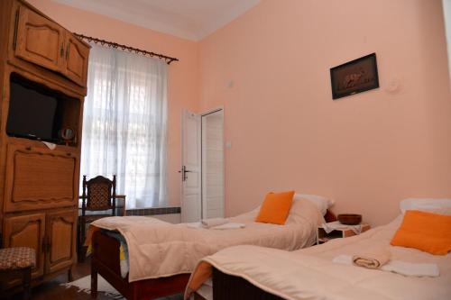 a bedroom with two beds and a tv and a window at APARTMANI STARI GRAD PRIBOJ in Priboj