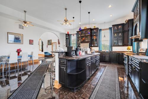 a large kitchen with black cabinets and a bar at The Starlight Tower Manor, River, Arcades, Observatory, Theater in Fort Atkinson