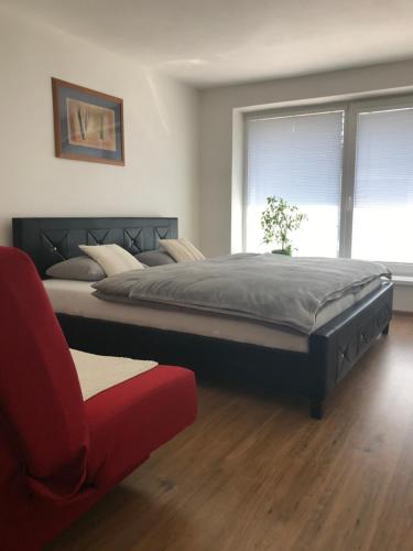 a bedroom with a large bed and a red couch at Apartman Emka 2 in Liptovský Mikuláš