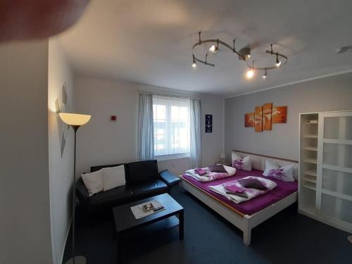 ein Wohnzimmer mit einem Sofa und einem Bett in der Unterkunft Residenz am Peeneplatz in Peenemünde