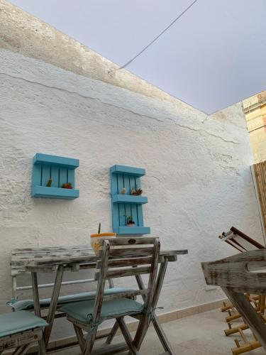 a table and chairs with blue shelves on a wall at La `Ssuta in Poggiardo