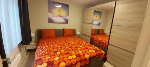 una camera da letto con un letto e un piumone arancione di Marjori Oostende met gratis parkeerplaats a Ostenda