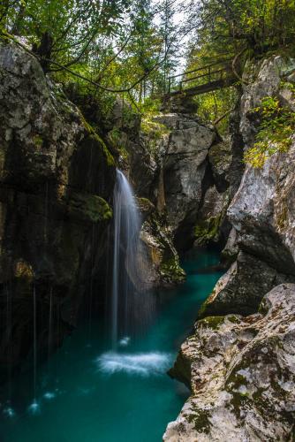 a waterfall in the middle of a pool of water at Apartmaji Prton Bovec in Bovec