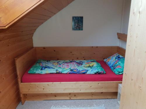 レンツキルヒにあるFerienwohnung Dorotheaの赤いマットレスが備わる木造キャビンのベッド1台分です。