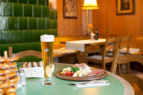 a table with a plate of food and a glass of beer at Hotel Landgasthof Hirschen in Ramsen