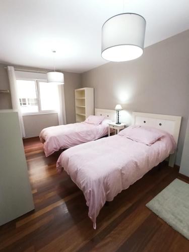a bedroom with two beds with pink sheets at Viveiro Histórico in Viveiro