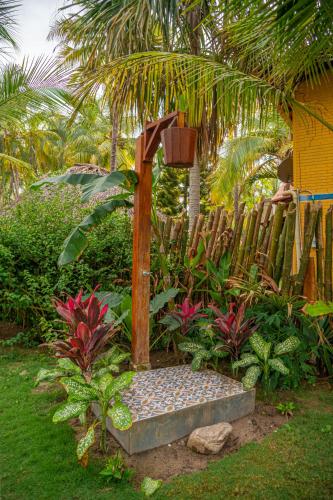 a garden with a bench in front of a fence at Casa Chapolin Boutique Guesthouse in Palomino