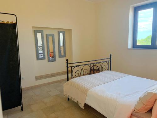 - une chambre avec un lit et deux miroirs sur le mur dans l'établissement Villa Elena by ApulianBnV, à Serranova